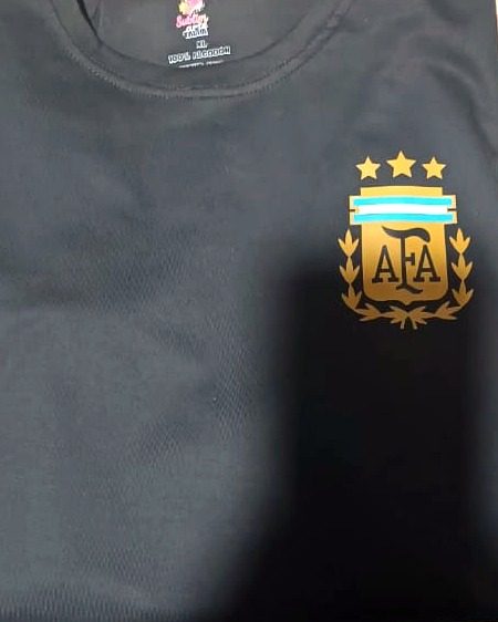 Remera negra con el escudo de la AFA y tres estrellas estampado en dorado sobre el pecho.